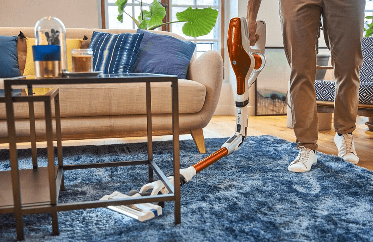 Man vacuuming under a wrought iron table