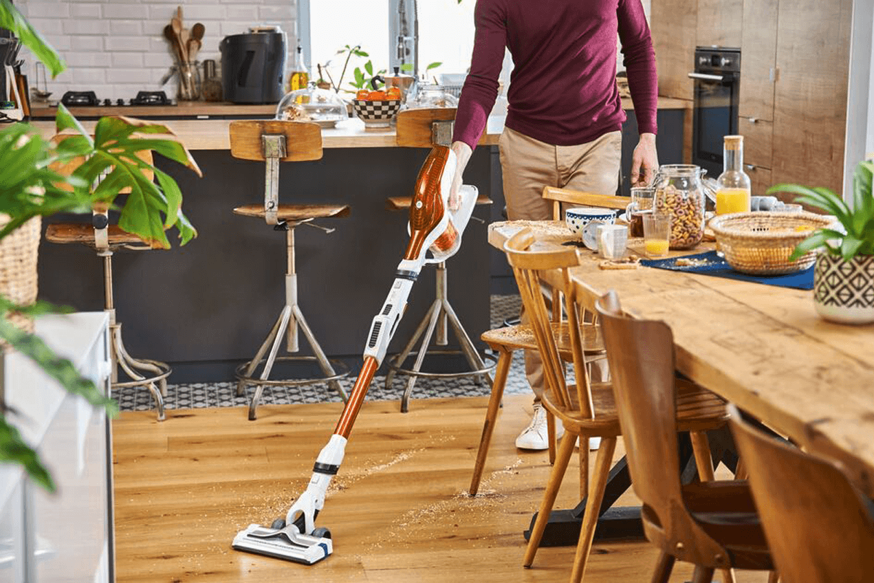 Man vacuuming in his kitchen