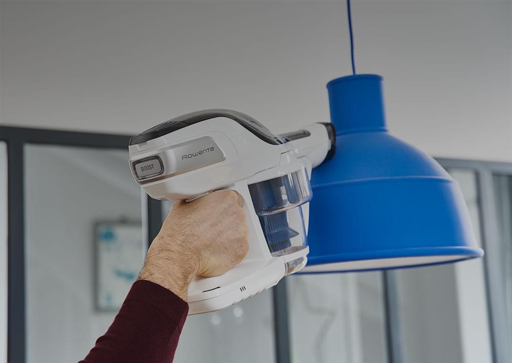 Man vacuuming on a lamp